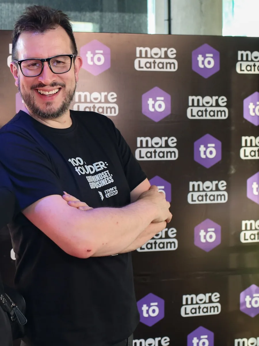 Alexander Torrenegra, de brazos cruzados y sonriendo, frente a un fondo con logos de Torre.